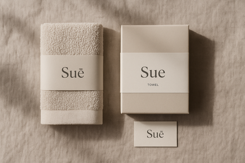 Toalla suē junto a su empaque minimalista y tarjeta de marca